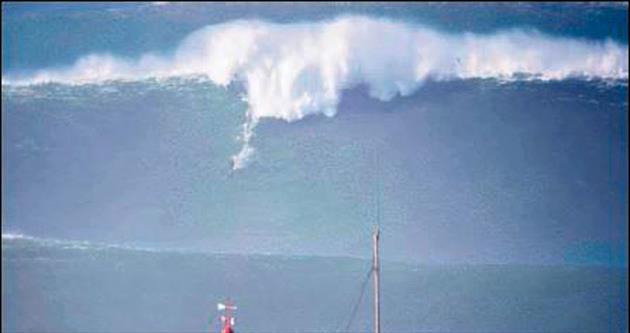 Dalga dağının zirvesinde sörf