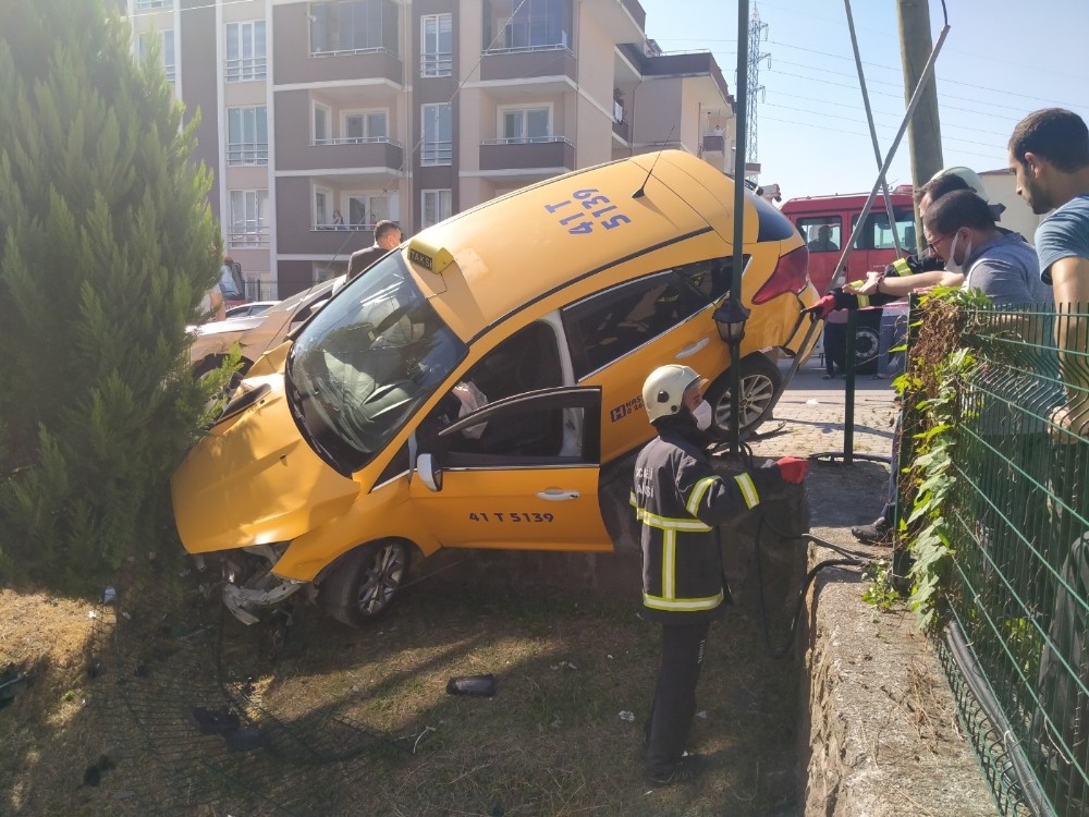 2 otomobille çarpışan ticari taksi bahçe duvarında asılı kaldı
