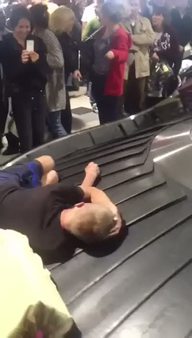 Havalimanında bagaj bandı üzerinde uyuyan adam
