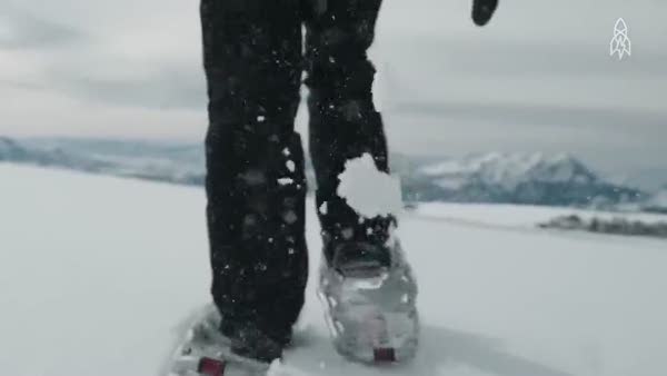 Karlı dağların üzerine ayaklarıyla enfes şekiller çizen sanatçı