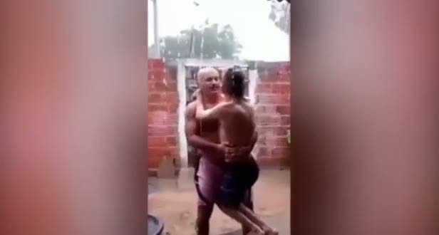 Yağmuru hissetmesi için engelli oğlunu kucağında taşıyan baba
